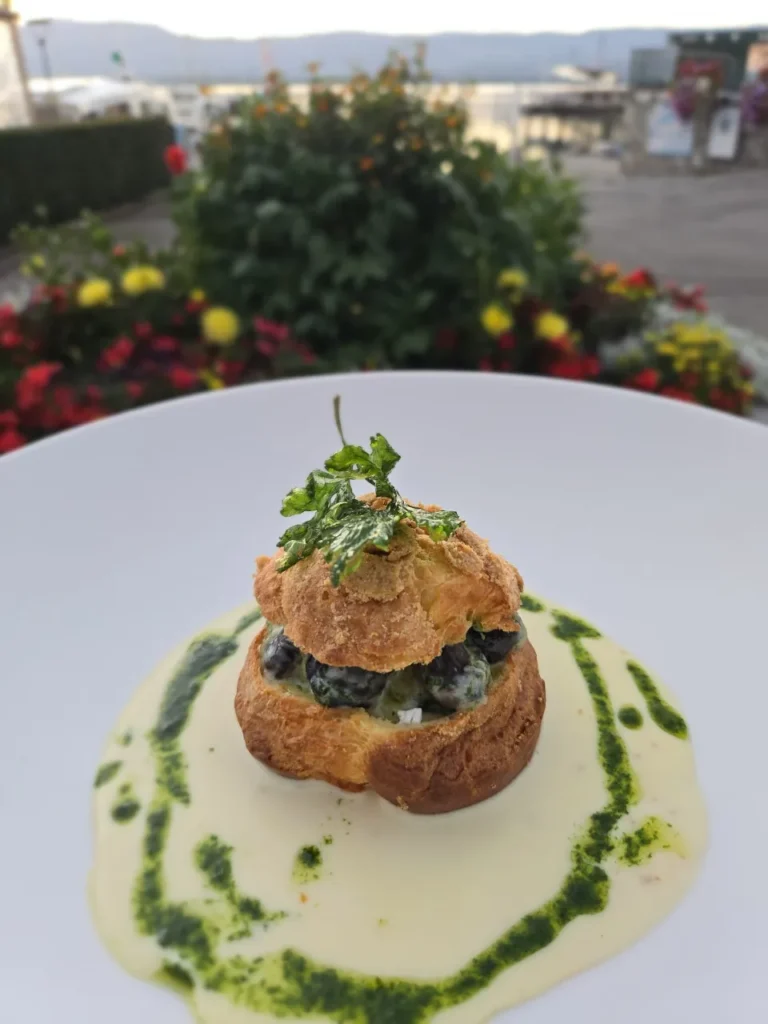 Profiteroles aux escargots, sauce crémeuse persillée et tuile de persil frit, en terrasse à Yvoire