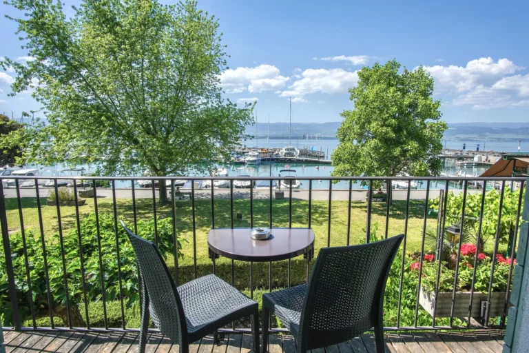 Table et chaises sur le balcon privatif avec vue sur le lac Léman