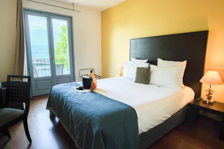 Chambre double balcon avec porte-fenêtre ouverte sur le lac