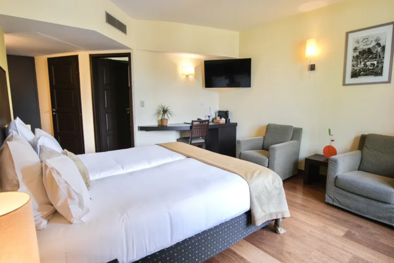 Chambre double balcon spacieuse avec canapé et coin salon