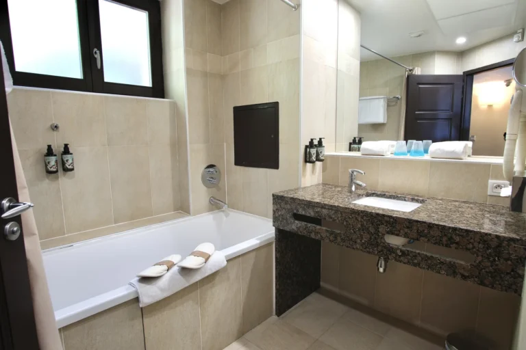 Salle de bain avec baignoire et vasque en granit, chambre balcon