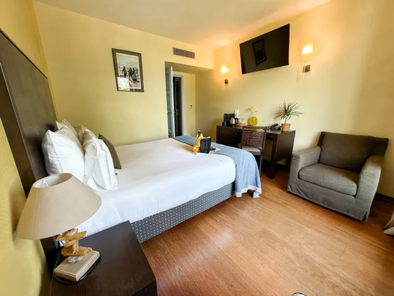 Chambre double balcon avec lit double et fauteuil