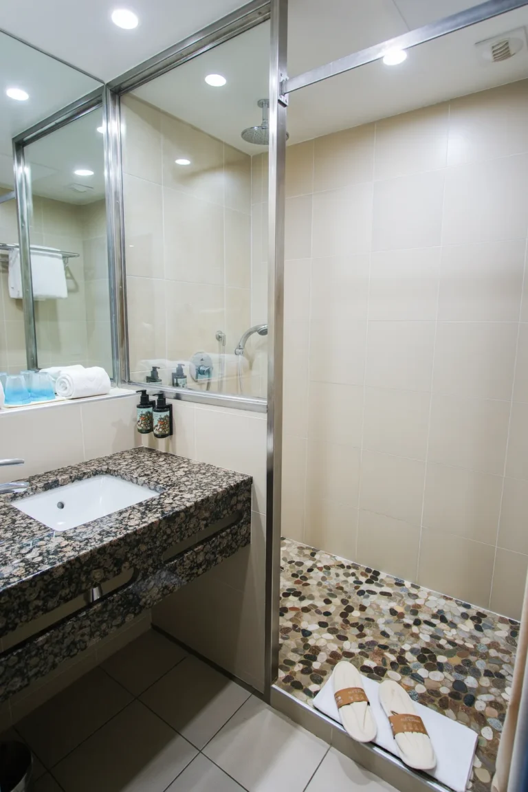 Salle de bain avec douche à l'italienne en galets, chambre balcon