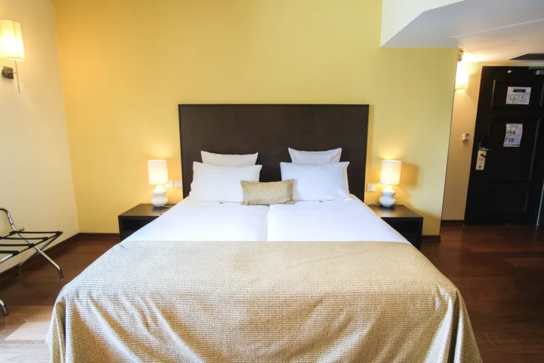 Lit double avec tête de lit en bois sombre, chambre double côté lac