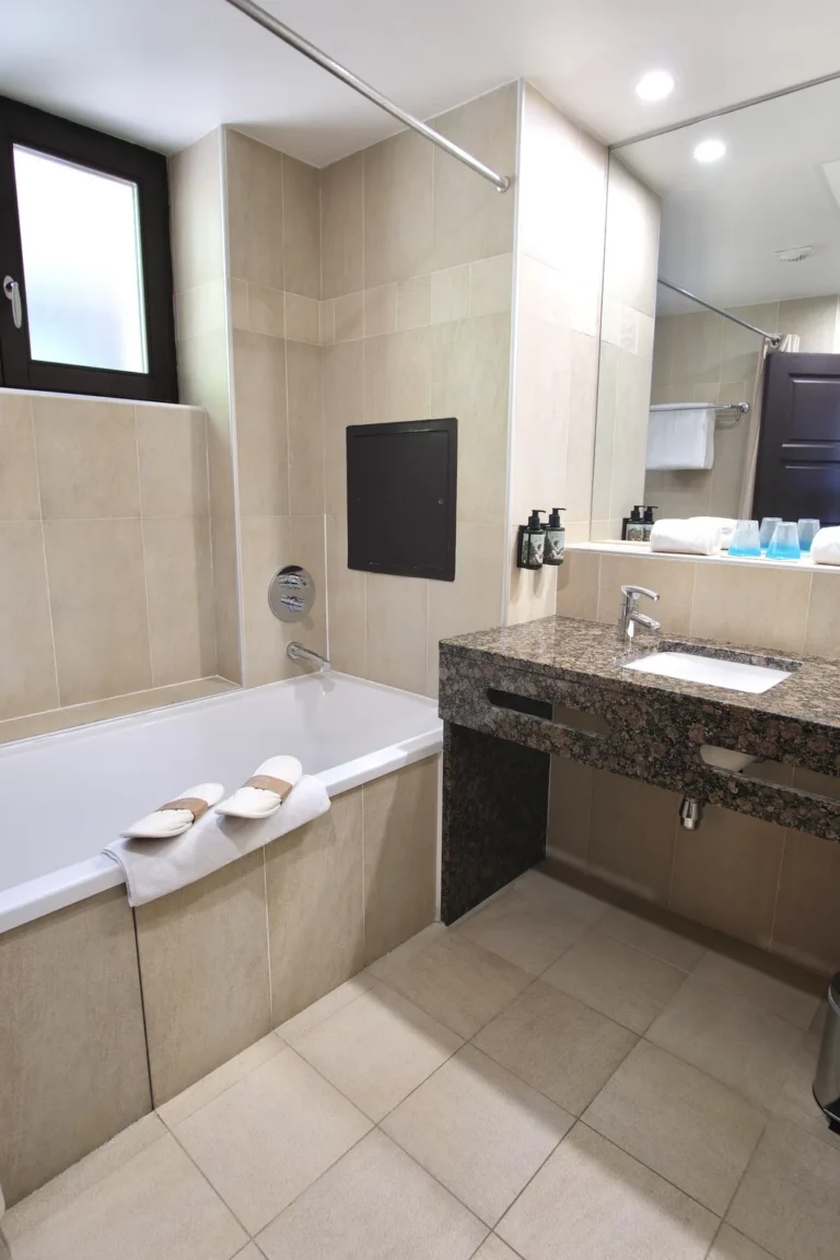 Salle de bain avec baignoire et vasque en granit, chambre côté lac