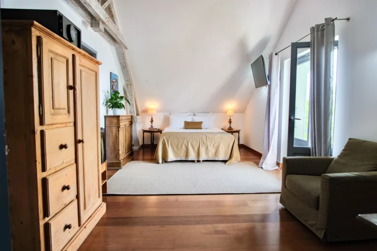 Chambre familiale spacieuse avec canapé et poutres apparentes