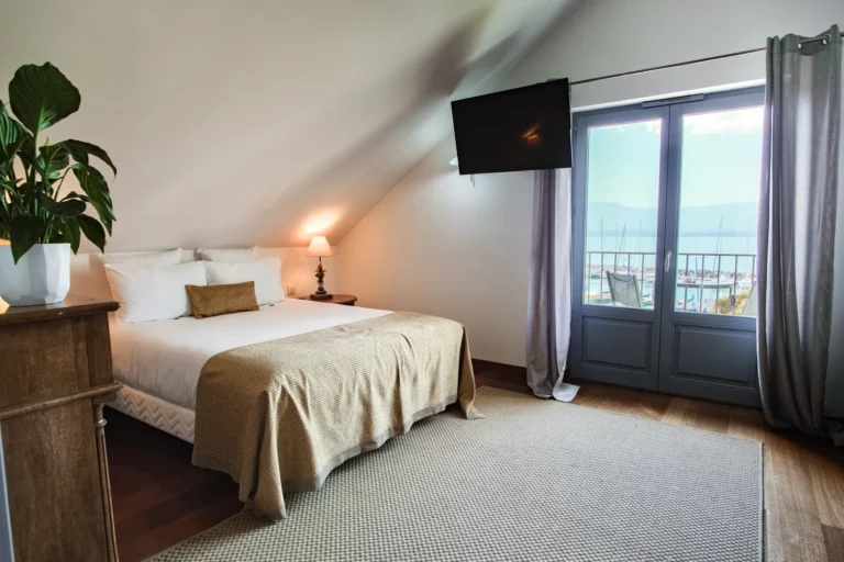 Lit double face à la porte-fenêtre avec vue sur le lac Léman, chambre familiale