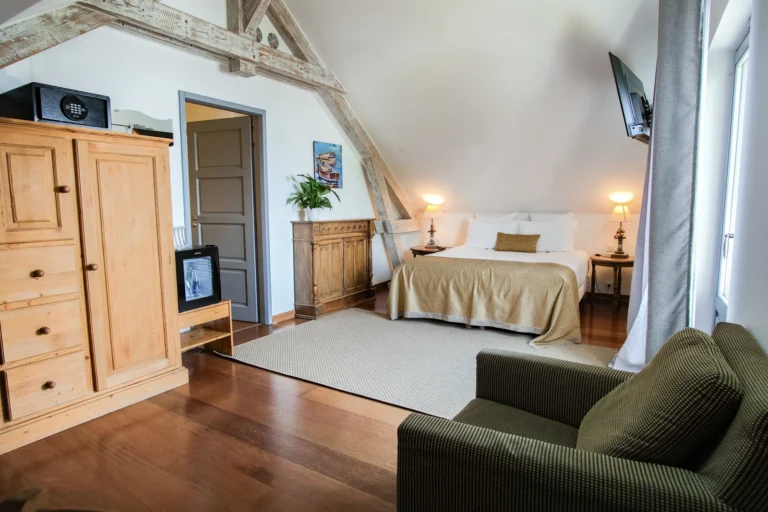 Chambre familiale avec armoire en bois et fauteuil