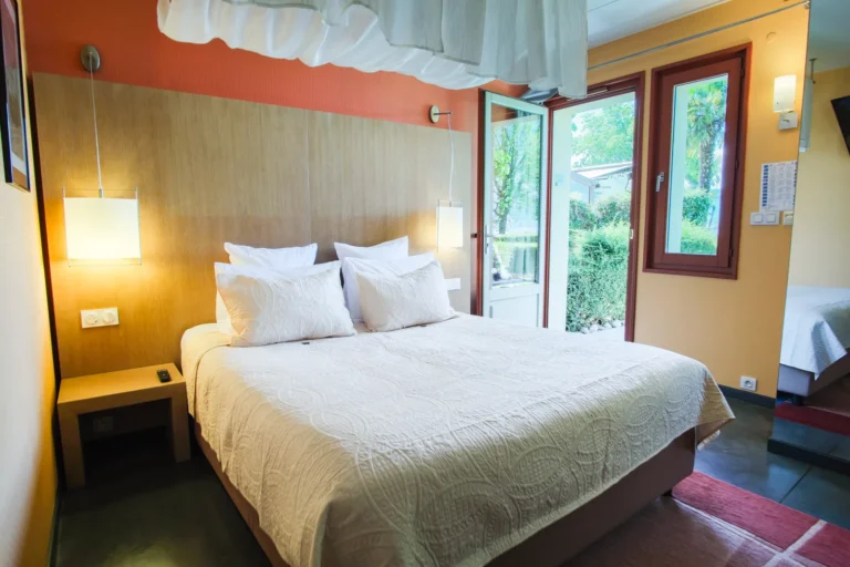 Lit double avec ciel de lit dans une chambre Lac Jardin lumineuse