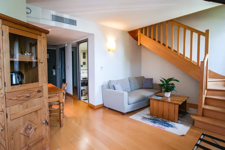 Salon de la suite duplex avec canapé et escalier menant à la chambre