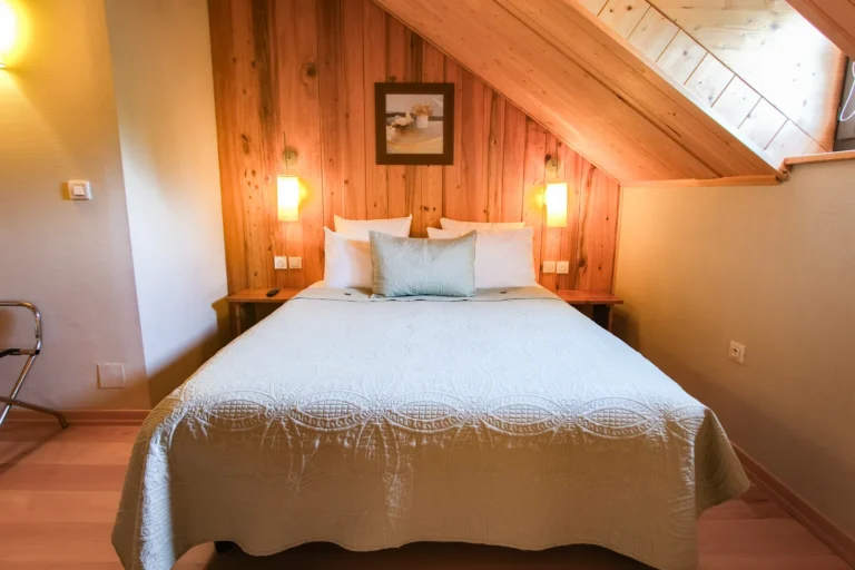 Chambre mansardée en bois avec lit double, suite duplex